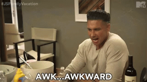A Man Is Sitting At A Table With A Bottle Of Wine And Says Awkward . GIF