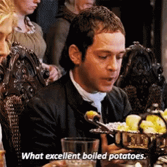 A Man Is Sitting At A Table With A Bowl Of Boiled Potatoes In Front Of Him . GIF