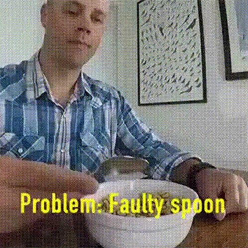 A Man Is Sitting At A Table With A Bowl Of Cereal And The Words Problem Faulty Spoon Behind Him GIF