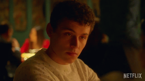 A Man Is Sitting At A Table With A Netflix Logo On The Bottom Right GIF