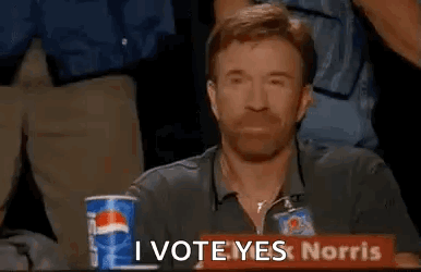 A Man Is Sitting At A Table With A Pepsi Cup And A Sign That Says `` I Vote Yeslorris '' . GIF