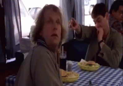 A Man Is Sitting At A Table With A Plate Of Food GIF