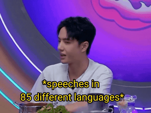 A Man Is Sitting At A Table With A Pot Of Food And The Words Speeches In 85 Different Languages Above Him GIF