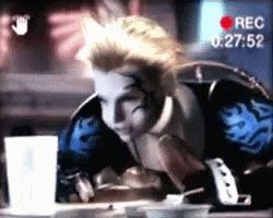 A Man Is Sitting At A Table With A Recorder Recording Him At 00:27:52 GIF