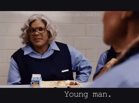 A Man Is Sitting At A Table With A Tray Of Food And A Milk Carton That Says ' Young Man ' On It GIF