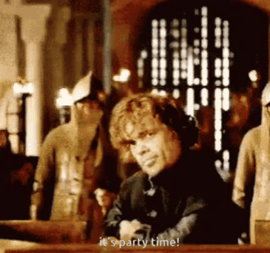 A Man Is Sitting At A Table With His Arms Crossed And Saying `` It 'S Party Time '' . GIF