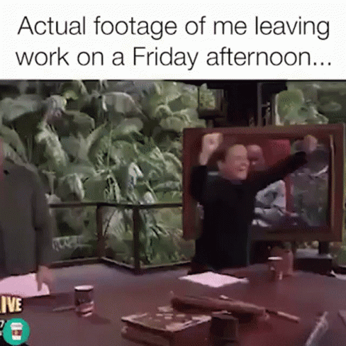 A Man Is Sitting At A Table With His Arms In The Air And A Caption That Says Actual Footage Of Me Leaving Work GIF