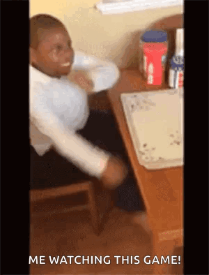A Man Is Sitting At A Table With His Hands On His Head And The Words `` Me Watching This Game '' Written On The Bottom . GIF