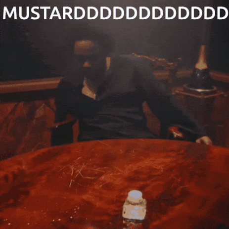 A Man Is Sitting At A Table With His Mouth Open And The Words Mustardddddddddddd On The Bottom GIF