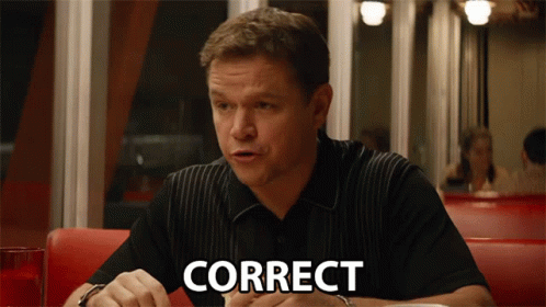 A Man Is Sitting At A Table With The Word Correct Written On His Face GIF