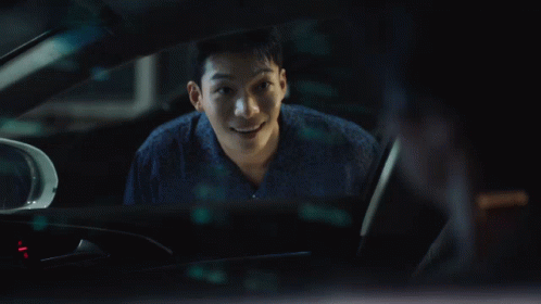 A Man Is Sitting In A Car And Smiling GIF