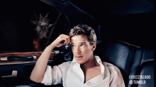 A Man Is Sitting In A Car Looking Out The Window At A Cat With Flames Coming Out Of It GIF