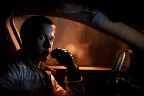 A Man Is Sitting In A Car With A Red Arrow Pointing To His Face GIF