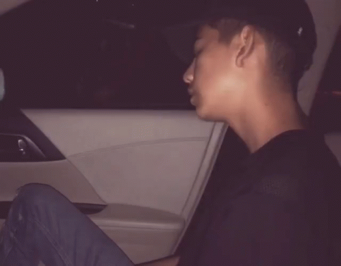a man is sitting in a car with the words day after day behind him
