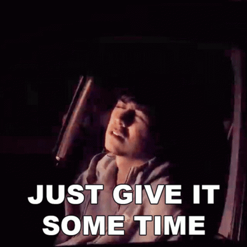 A Man Is Sitting In A Car With The Words Just Give It Some Time Above Him GIF