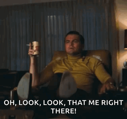 A Man Is Sitting In A Chair And Pointing At Something With The Words Oh Look Look That Me Right There Below Him GIF