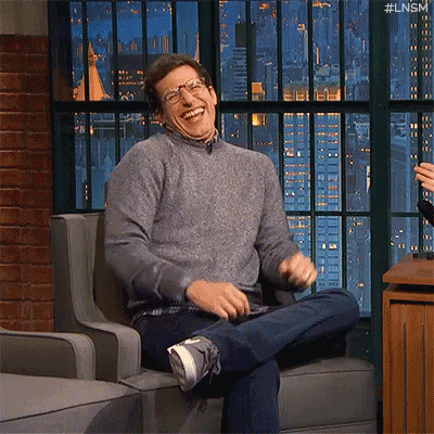 Man Sitting Laughing In Glasses And Sweater GIF