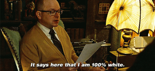 A Man Is Sitting In A Chair Reading A Piece Of Paper And Says It Says Here That I Am 100 % White GIF