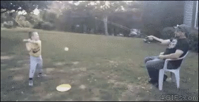 A Man Is Sitting In A Chair While A Boy Throws A Frisbee In The Air . GIF