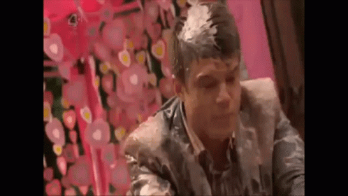 A Man Is Sitting In A Chair With A Lot Of Foam On His Head . GIF