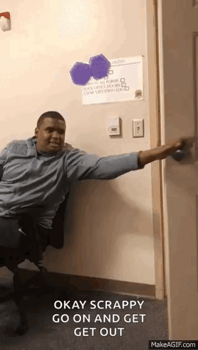 A Man Is Sitting In A Chair With His Arm Outstretched And Says Okay Scrappy Go On And Get Out .. GIF
