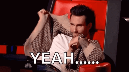 A Man Is Sitting In A Chair With His Arms Outstretched And Says Yeah GIF