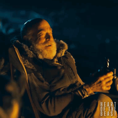 A Man Is Sitting In A Chair With The Words Heart Of The Beast Written On The Bottom GIF