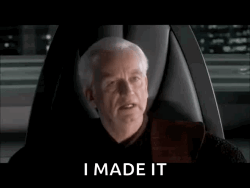 A Man Is Sitting In A Chair With The Words `` I Made It '' Written On The Screen . GIF