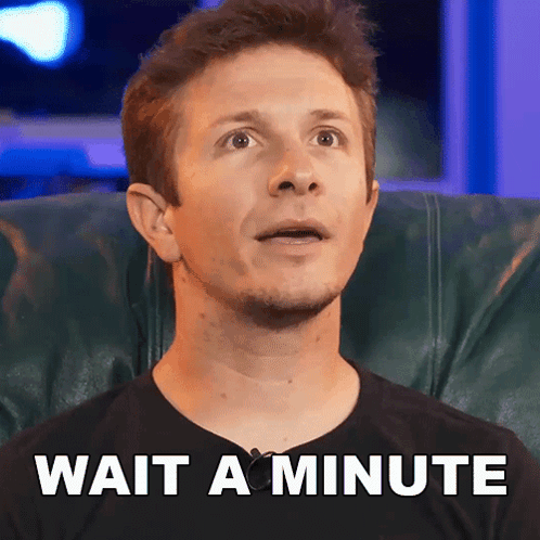 A Man Is Sitting In A Chair With The Words Wait A Minute Written On The Bottom GIF