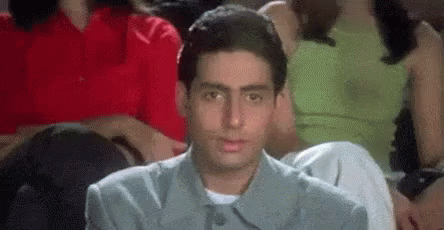 A Man Is Sitting In A Crowd Of People Watching A Movie And Making A Funny Face . GIF