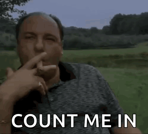 A Man Is Sitting In A Field With His Finger To His Mouth And The Words `` Count Me In '' Written On The Screen . GIF