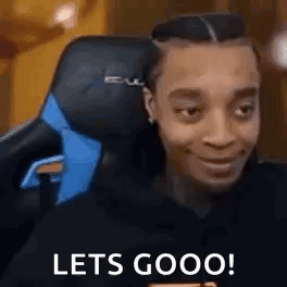 A Man Is Sitting In A Gaming Chair With The Words `` Lets Goooo '' Written On His Face . GIF