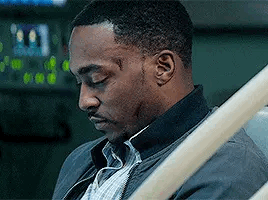 A Man Is Sitting In A Hospital Bed With His Eyes Closed And A Scar On His Face . GIF
