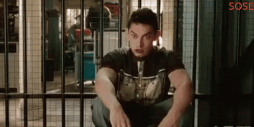 A Man Is Sitting In A Jail Cell With The Word Sose On The Bottom Right GIF