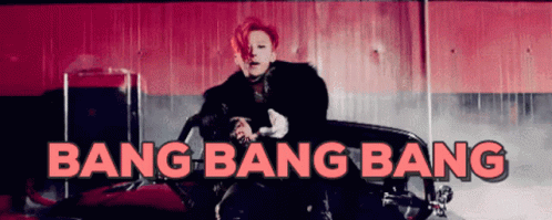 a man is sitting in a red car with the words bang bang bang above him