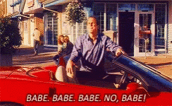 a man is sitting in a red sports car with the words babe babe babe no babe