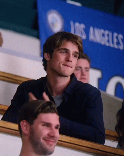 A Man Is Sitting In A Stadium In Front Of A Los Angeles Banner GIF