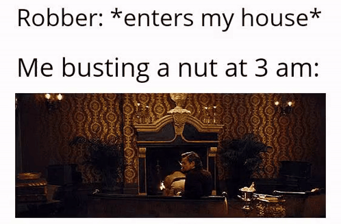 A Man Is Sitting In Front Of A Fireplace In A Room With A Statue On The Wall . GIF