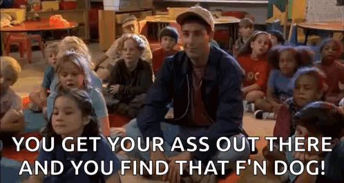 A Man Is Sitting In Front Of A Group Of Children In A Classroom And Talking To Them . GIF