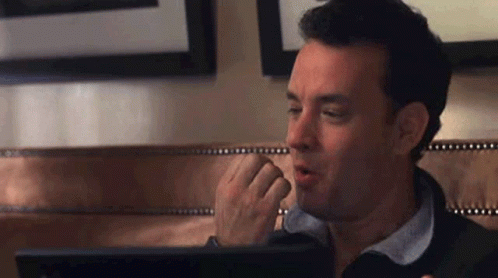 A Man Is Sitting In Front Of A Laptop Computer . GIF