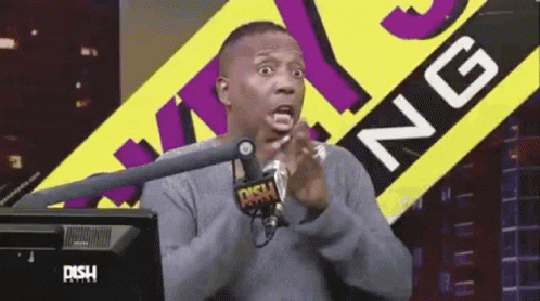 A Man Is Sitting In Front Of A Microphone In Front Of A Sign That Says Dish Radio GIF