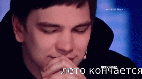 A Man Is Sitting In Front Of A Microphone With His Eyes Closed And His Hands Folded . GIF