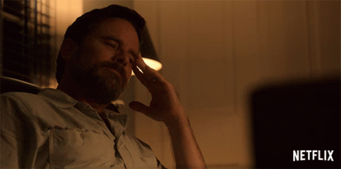 A Man Is Sitting In Front Of A Netflix Sign GIF
