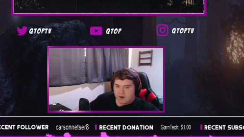 A Man Is Sitting In Front Of A Screen That Says Qtoptv On It GIF