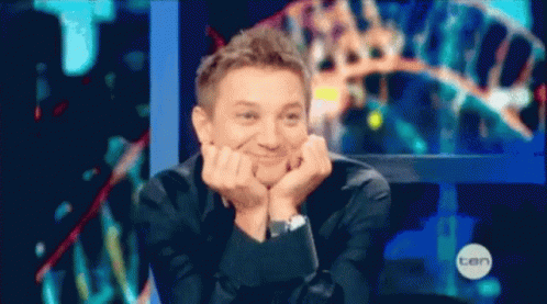 A Man Is Sitting In Front Of A Screen That Says Ten On It GIF