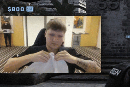A Man Is Sitting In Front Of A Sign That Says $ 800 On It GIF