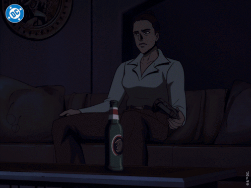 A Man Is Sitting In Front Of A Television With A Dc Logo On The Screen GIF