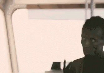 A Man Is Sitting In Front Of A Window On A Bus And Looking Out The Window . GIF