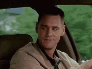 A Man Is Sitting In The Back Seat Of A Car Looking At The Camera . GIF