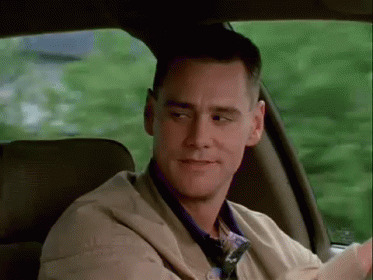 A Man Is Sitting In The Back Seat Of A Car Looking Out The Window . GIF